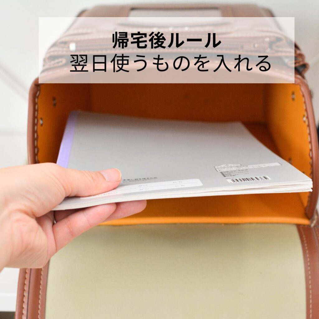 ランドセルに翌日のノートを入れている手元写真