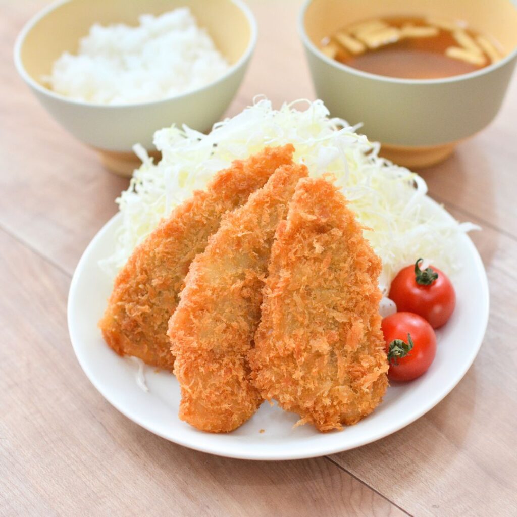 アジフライをキャベツと一緒に皿に盛り付けた様子