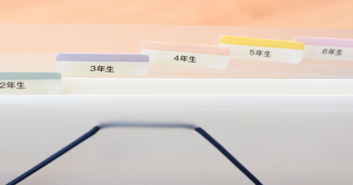 じゃばら式ファイルに学年ごとラベルを貼って通知表を収納している様子