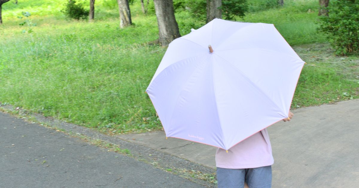 小川キッズ日傘を外でさしている子どもの後ろ姿