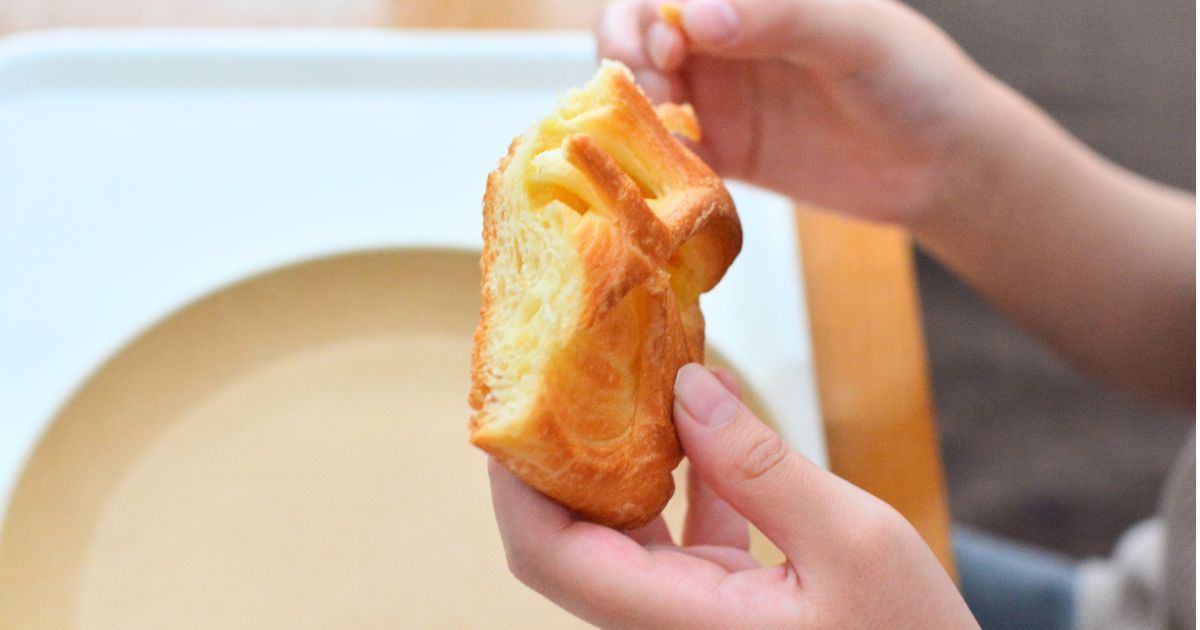 KOUBOのスイートポテトパイを手に持つ子ども