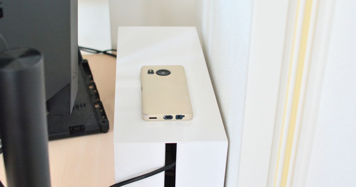 山崎実業の白いケーブルボックスの上にスマートフォンを置いたサイズ比較